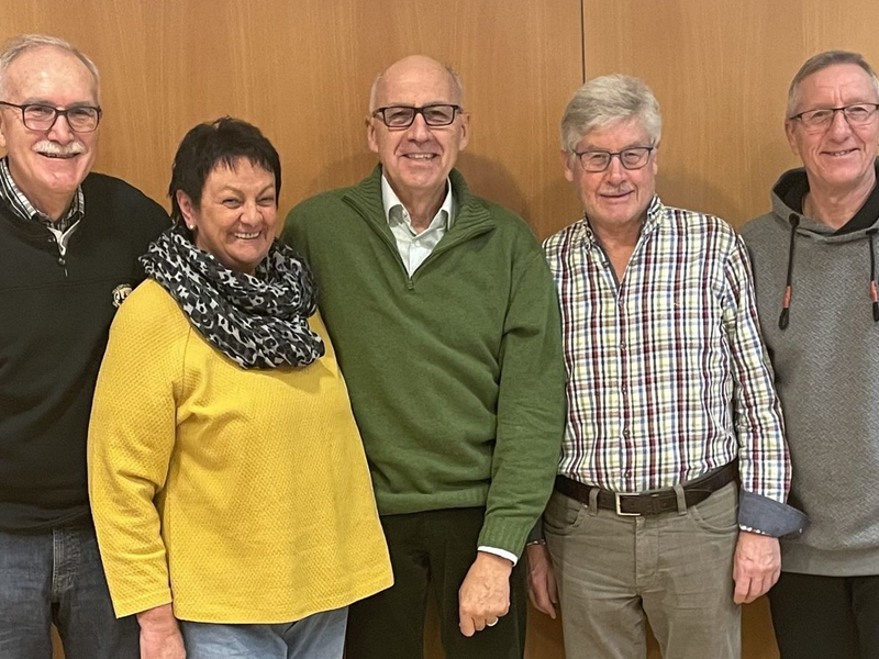 Das Team der Initiative Unterstützung im Schriftverkehr wartet auf ihre Anliegen stehend vor einer Wand.